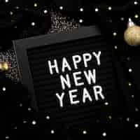 Free photo new year lettering on dark background with lights