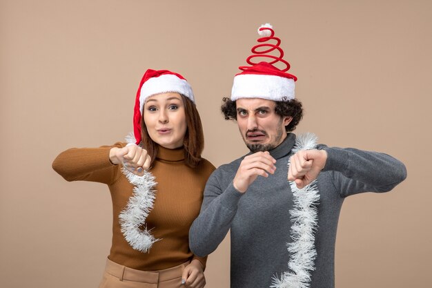 New year mood festive concept with excited cool satisfied lovely couple wearing red santa claus hats