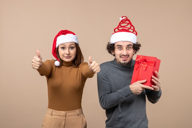 New year mood festive concept with funny happy lovely couple wearing red santa claus hats on gray footage