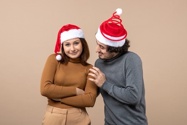 New year mood and party concept - young excited lovely couple wearing santa claus hats on gray stock