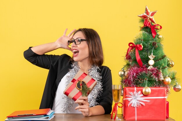 New year mood with beautiful business lady in suit with glasses and sitting at a table in the office