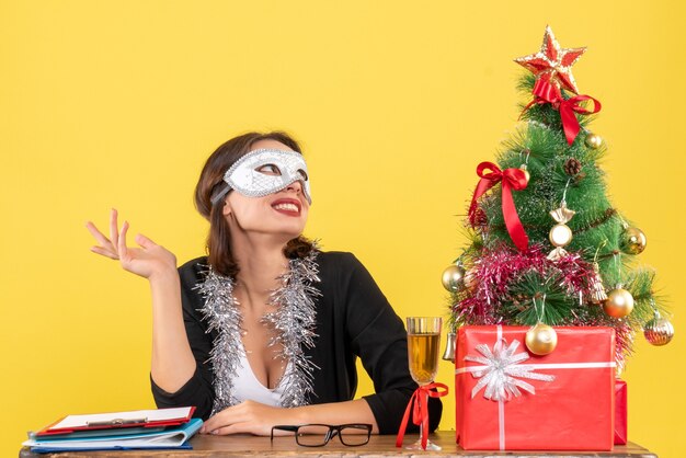 New year mood with dreamy charming lady in suit wearing mask in the office 