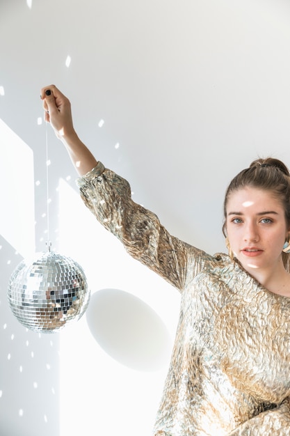 Foto gratuita concetto del partito del nuovo anno con la palla della discoteca della tenuta della ragazza