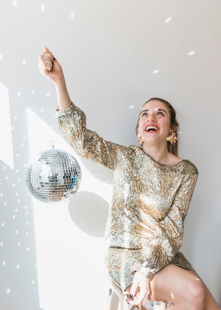 Foto gratuita concetto del partito del nuovo anno con la palla della discoteca della tenuta della ragazza