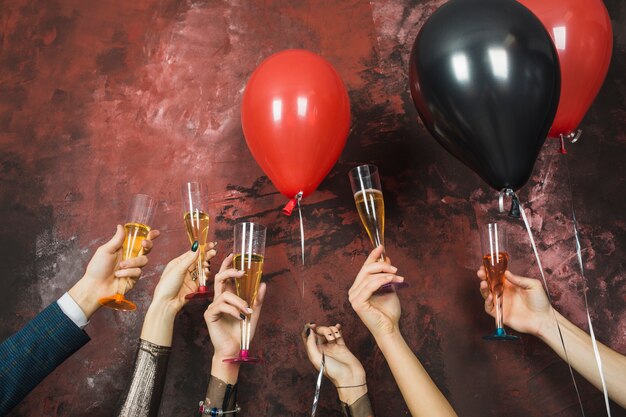 Foto gratuita concetto di festa di capodanno con mano alzando bicchieri di champagne