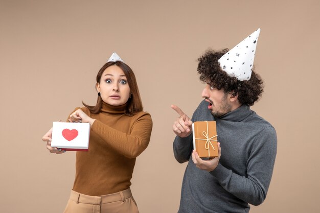 New year shooting with emotional crazy confused young couple wear new year hat girl with heart