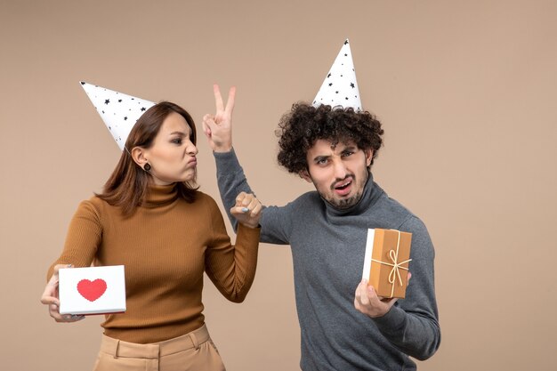 New year shooting with emotional crazy shocked young couple wear new year hat angry girl