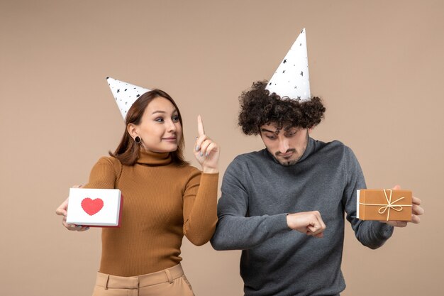 New year shooting with young couple wear new year hat happy girl with heart pointing up and guy