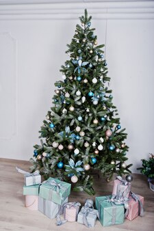 白い​部屋​で​おもちゃ​や​ギフト​と​新年​の​木​。​幸せな​冬​の​休日​の​コンセプト​。