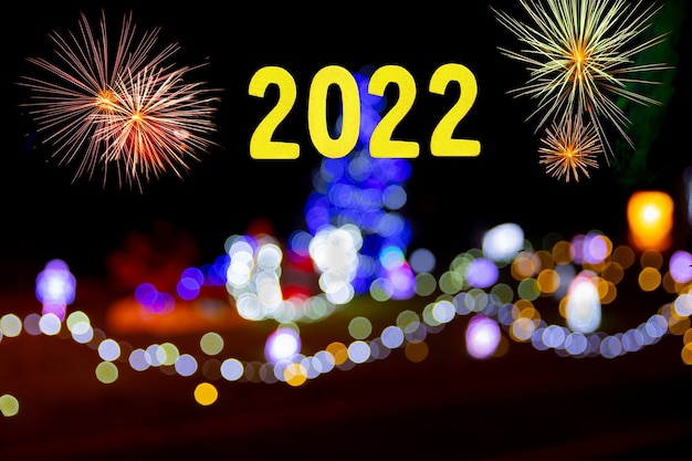 New years card for 2022 with gold numbers on a background of fireworks and colored lights.