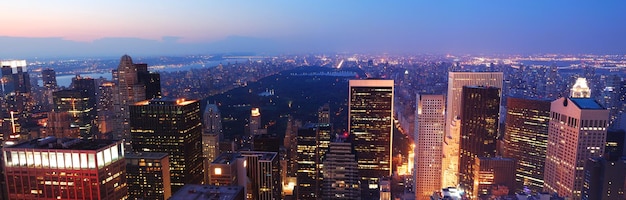 マンハッタンのスカイラインと夕暮れ時の高層ビルのあるニューヨーク市セントラルパークの空撮パノラマ