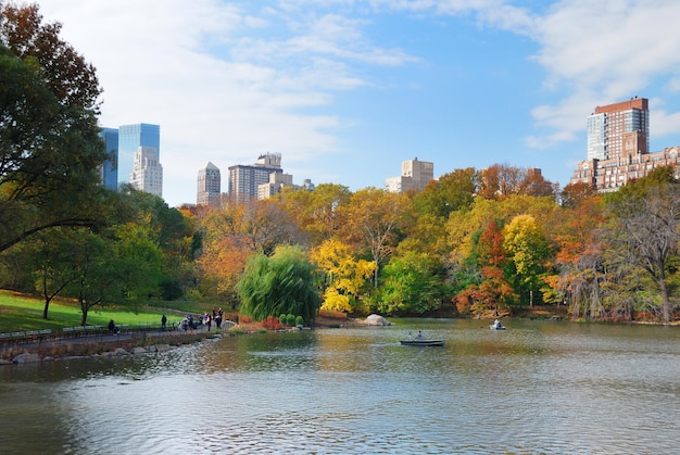 高層ビルと反射のある色とりどりの木々がある秋の湖のニューヨーク市マンハッタンセントラルパークのパノラマ。