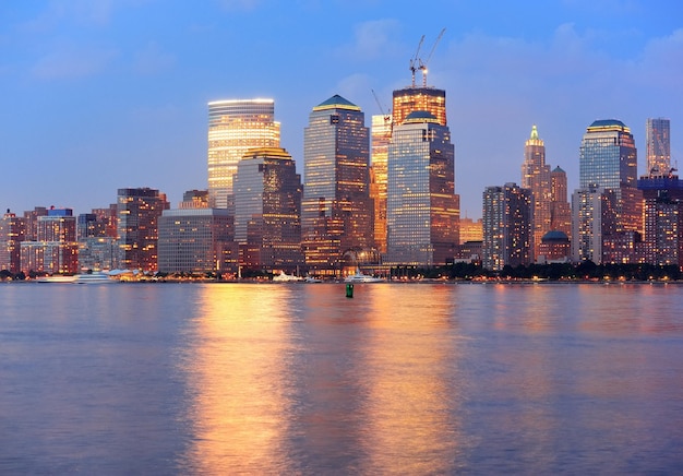 황혼에 허드슨 강 파노라마 위로 고층 빌딩이 조명된 뉴욕 맨해튼 시내 스카이라인