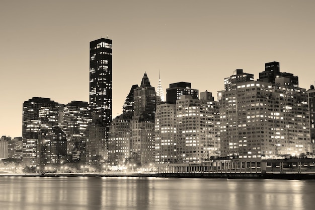 New York City Manhattan midtown skyline black and white at night over East River.