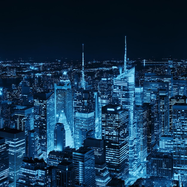 New York City midtown skyline with skyscrapers and urban cityscape at night.