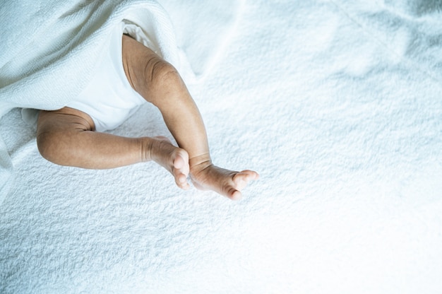 Newborn baby feet on a white blanket