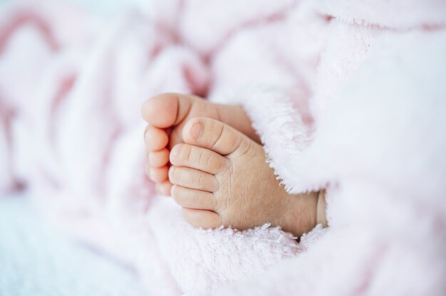 Newborn baby feet on a white blanket