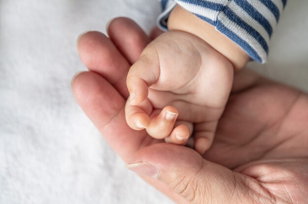 Newborn baby hand in white bed