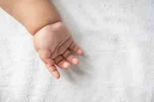 Free photo newborn baby hand in white bed