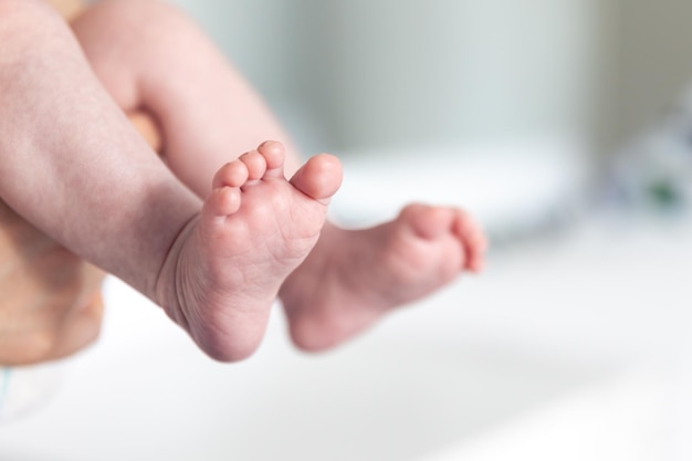 Free photo newborn baby in mothers hands legs closeup