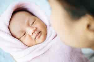 Free photo newborn baby sleeping in the arms of the mother