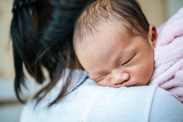 Newborn baby sleeping on the mother's shoulder