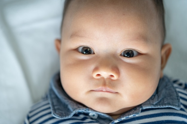 Новорожденный ребенок, который открывает глаза и смотрит вперед