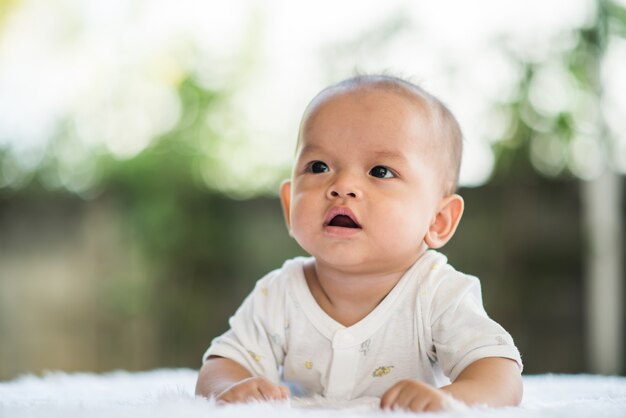 Newborn child relaxing on a rug.