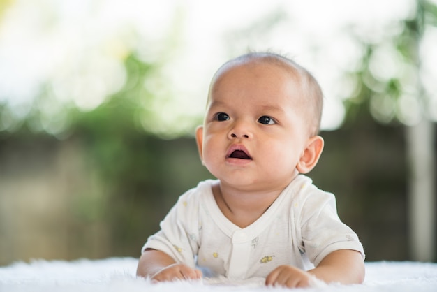 Newborn child relaxing on a rug.