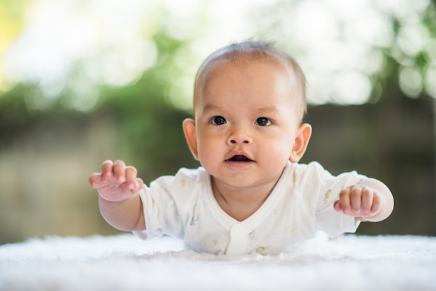 Newborn child relaxing on a rug.