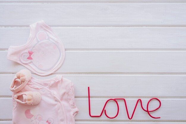 Newborn concept with baby clothes and love letters