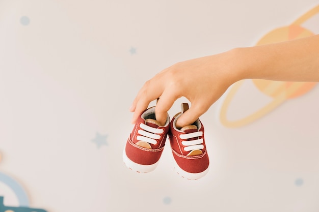 Newborn concept with fingers holding shoes