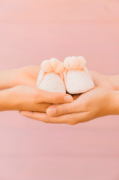 Newborn concept with holding hands and small shoes