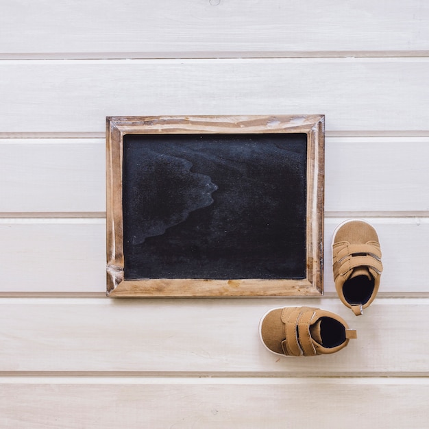 Newborn concept with shoes and slate