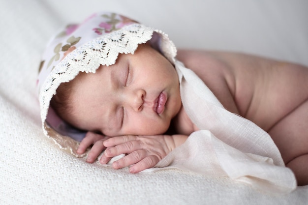 Newborn sleeping on stomach light background real life lifestyle