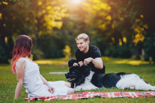 ニューファンドランド​犬​は​公園​で​男女​と​遊ぶ