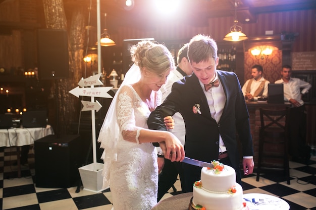 Newlywed couple cutting wedding cake