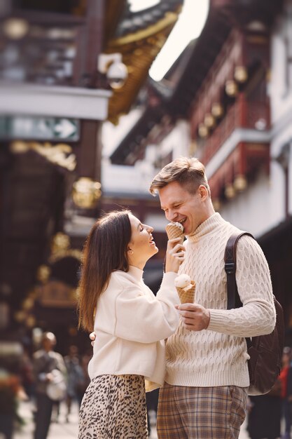 中国のyuan園近くの上海の通りでコーンからアイスクリームを食べる新婚カップル。