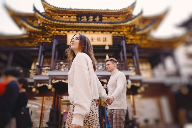 Newlywed couple showing affection and holding hands in Shanghai near Yuyuan while visiting China