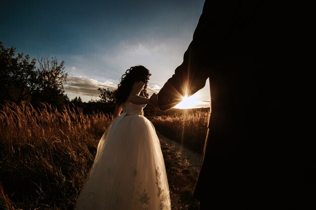 Newlyweds in the field at sunset