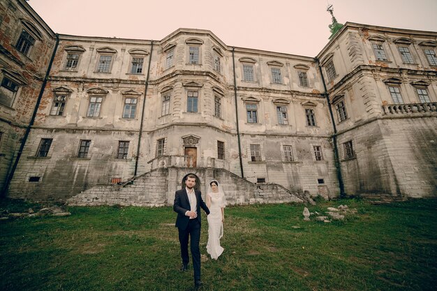 Newlyweds in front of a large house