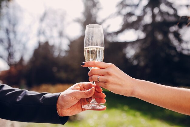 シャンパンのグラスを保持している新婚夫婦