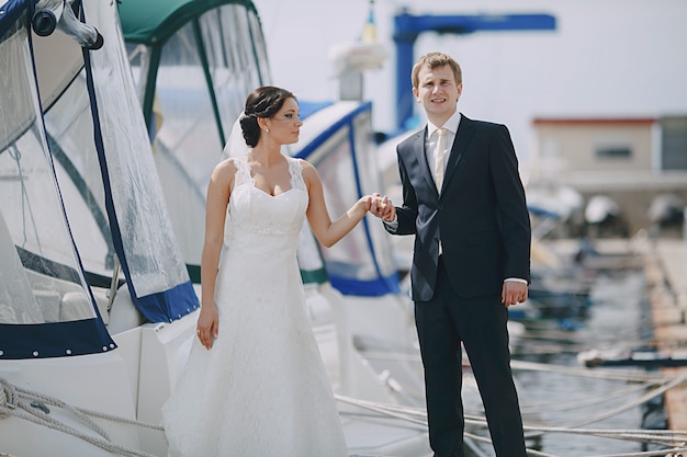 Newlyweds holding hands at the seaport