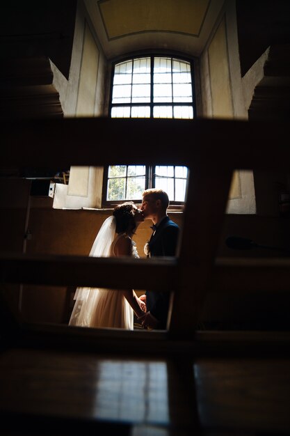 Newlyweds kissing in the dark