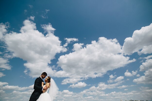 空の背景でお互いを見て新婚夫婦