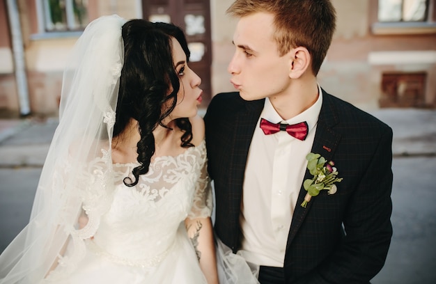 Newlyweds making faces while posing on street