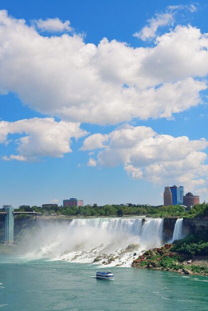 Niagara Falls closeup in the day over river with rocks and boat