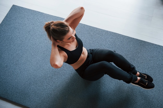 Bella bionda. fare gli addominali sul pavimento in palestra. bella donna fitness femminile