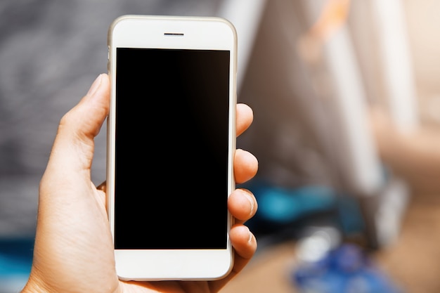 Nice close-up shot of modern gadget in hand. Beautiful phone with laconic design is a super useful device in modern era of high technologies with all mobile applications used.