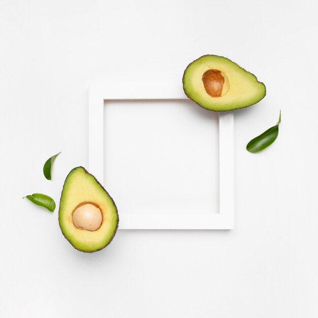 Nice composition of avocado on white surface with a frame for text